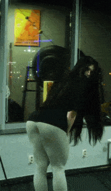 a woman with long hair is standing in front of a window with a sign on it that says ' make a difference '