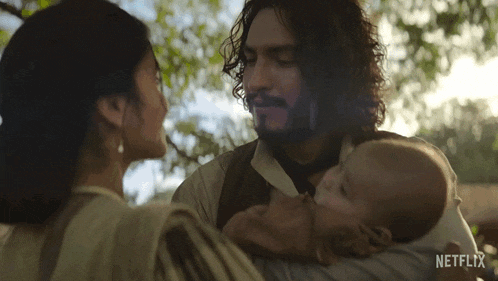 a man and woman holding a baby with netflix written on the bottom right
