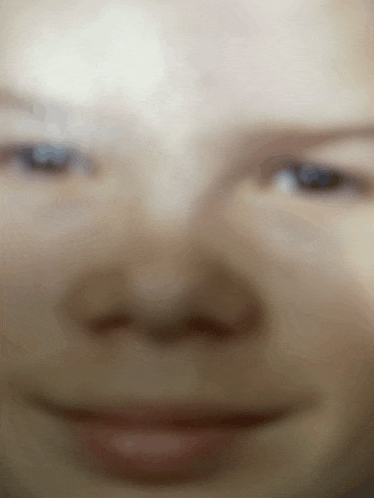 a blurry picture of a person 's face with a smile on their face
