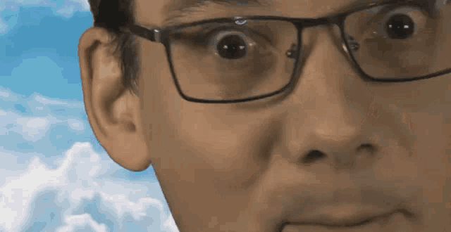 a close up of a man wearing glasses making a funny face