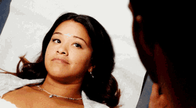 a woman is laying in a hospital bed with a man standing behind her