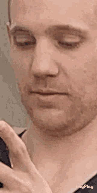 a close up of a man 's face with his eyes closed and a beard .