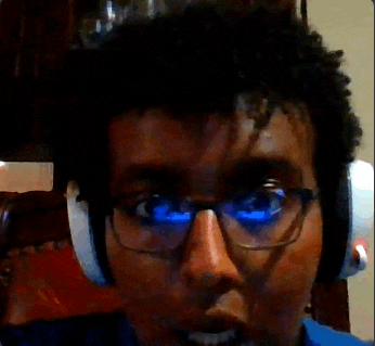 a man wearing headphones and glasses is looking at the camera