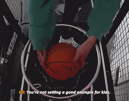 a person is holding a basketball in a hoop and says " you 're not setting a good example for kids "