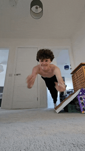 a shirtless man is doing push ups in a hallway