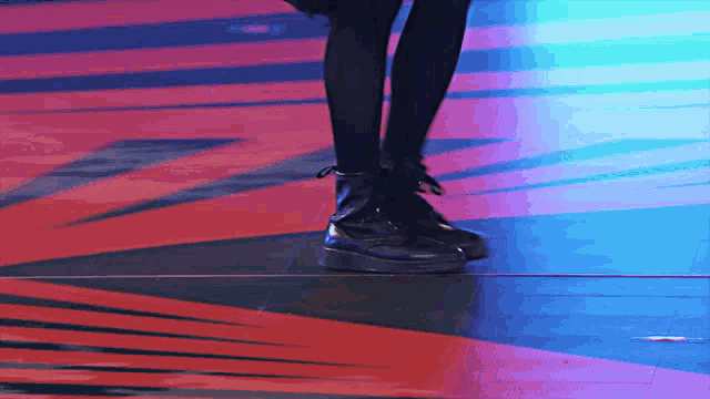 a person 's feet are shown in a blurry photo with a red and blue background