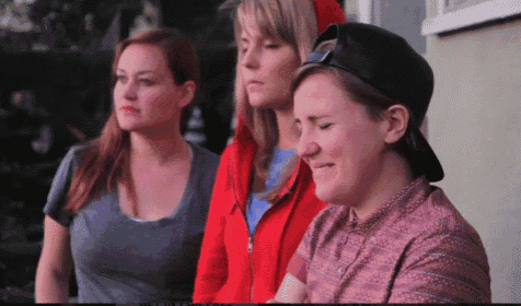 three women standing next to each other with one wearing a hat