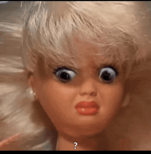 a close up of a doll with a question mark on the bottom