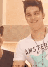 a man wearing a shirt that says amster on it smiles