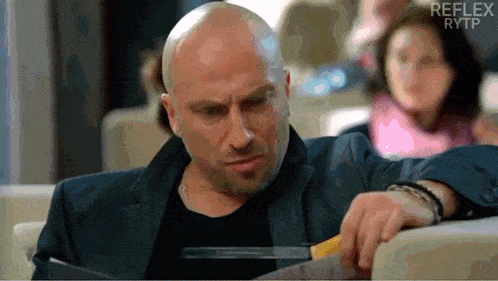 a bald man in a suit is holding a pair of scissors in front of a reflex rytp logo