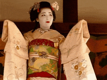 a woman in a kimono with a fan on her sleeve