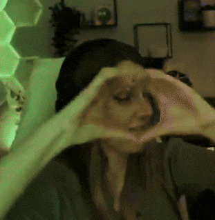 a woman makes a heart shape with her hands