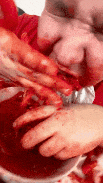a person with blood on their face is eating a hot dog