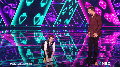 a man and a boy are on a stage with a nbc logo in the corner