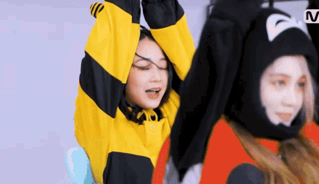 a woman wearing a bee costume is standing next to another woman