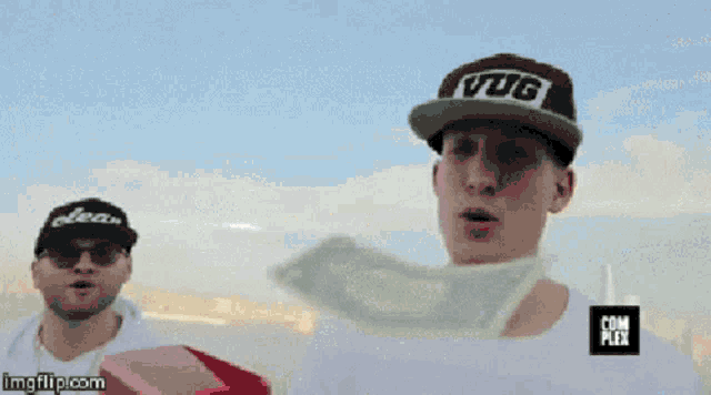 a man wearing a vug hat is holding a large amount of money