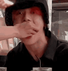 a close up of a person covering their mouth with a hand