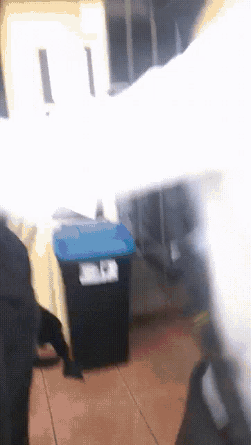 a black garbage can with a blue lid that says ' jc ' on it