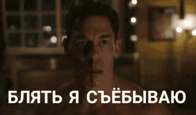 a man is doing a handstand in a dark room with the words in russian behind him