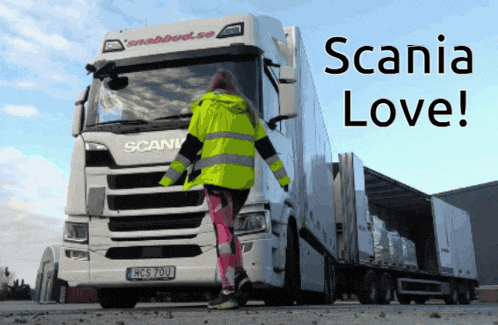 a woman standing in front of a scania truck that says scania love