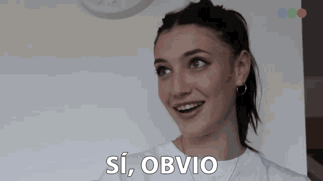 a woman in a white shirt is smiling with the words si obvio below her