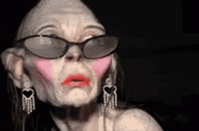 a close up of a woman wearing sunglasses and earrings