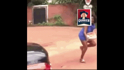 a woman in a blue dress is walking down a dirt road with a quaker logo on her head