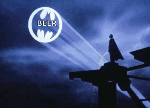 a silhouette of batman standing on top of a building in front of a beer logo