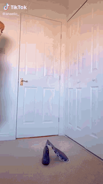 a pair of blue rain boots laying on the floor in front of a white door