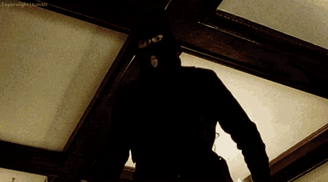 a person in a black mask is standing in a dark room with a caption that says coprolight.tumblr