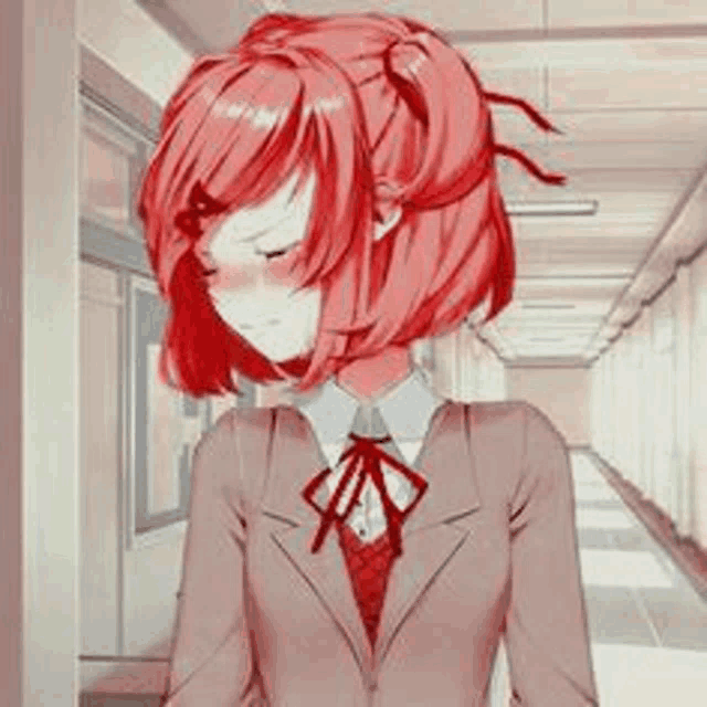 a girl with red hair is standing in a hallway wearing a suit and bow tie .