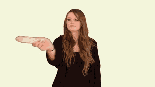 a woman in a black dress is holding a bottle in her hand .
