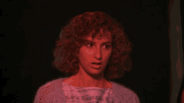 a woman with red hair is looking at something