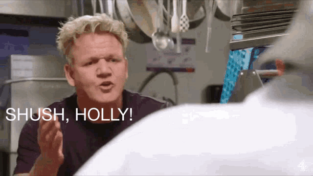 a man in a kitchen with the words shush holly behind him
