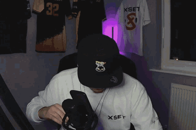 a man wearing a hat and a shirt that says xset on it