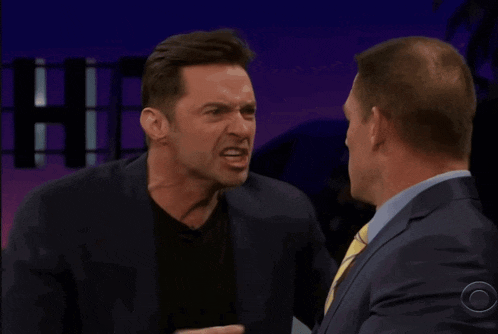 two men are having a conversation and one of them is pointing at the other and says me you
