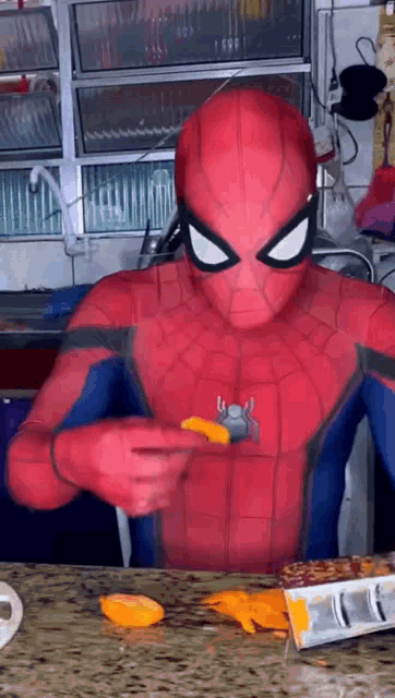a man in a spiderman costume is eating a piece of food