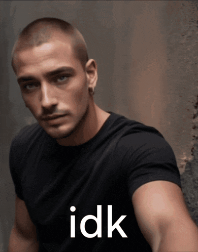 a man wearing a black shirt with the word idk on the front