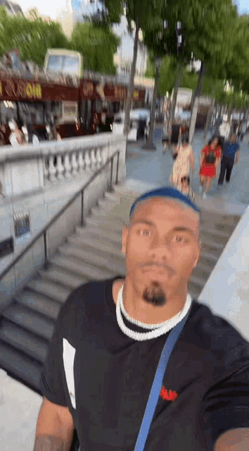 a man taking a selfie in front of stairs with a bus that says euro on top