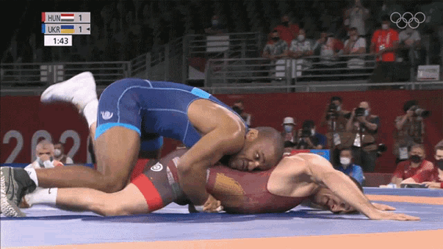 a wrestling match between hungary and ukraine is being shown on a screen