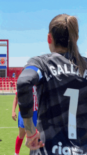 a female soccer player wearing a black jersey with the number 1 on it