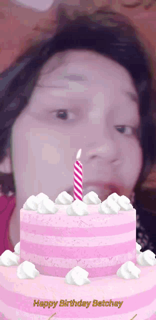 a woman blowing out a candle on a birthday cake with the words happy birthday betchay