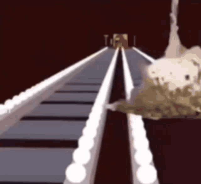 a computer generated image of a roller coaster with a statue in the background .