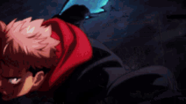 a man in a red hoodie is laying on the ground with his eyes closed .