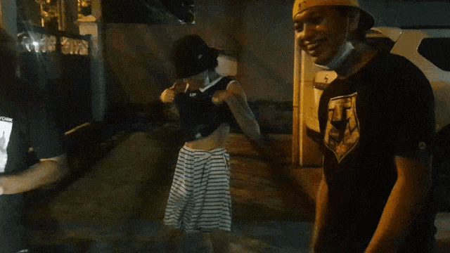 a man wearing a hat stands next to a woman wearing a shirt that says nike