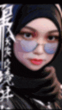 a blurry picture of a woman wearing a black hijab and glasses