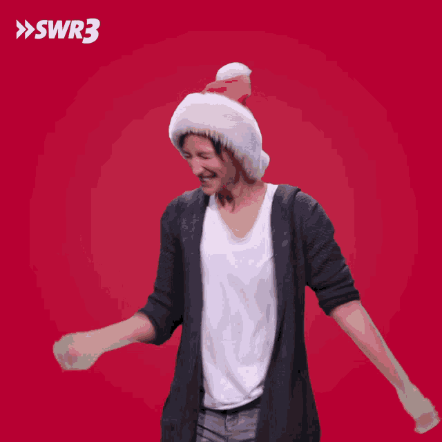 a woman wearing a santa hat is dancing in front of a red background with swr3 written above her