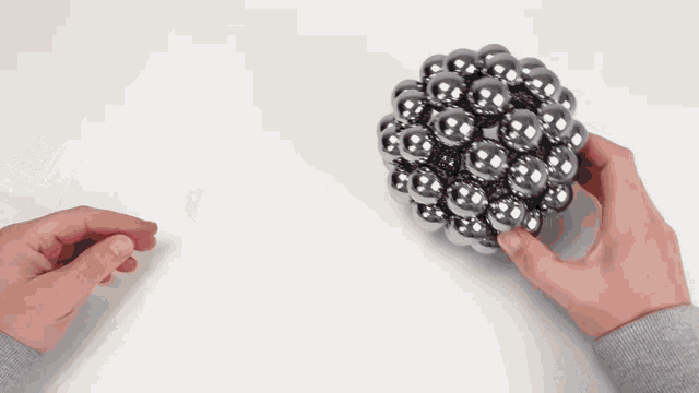 a person holding a bunch of silver balls in their hands