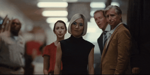 a group of people are standing in a hallway looking at the camera