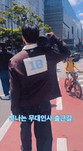 a man with the number 18 on his back is walking down the street